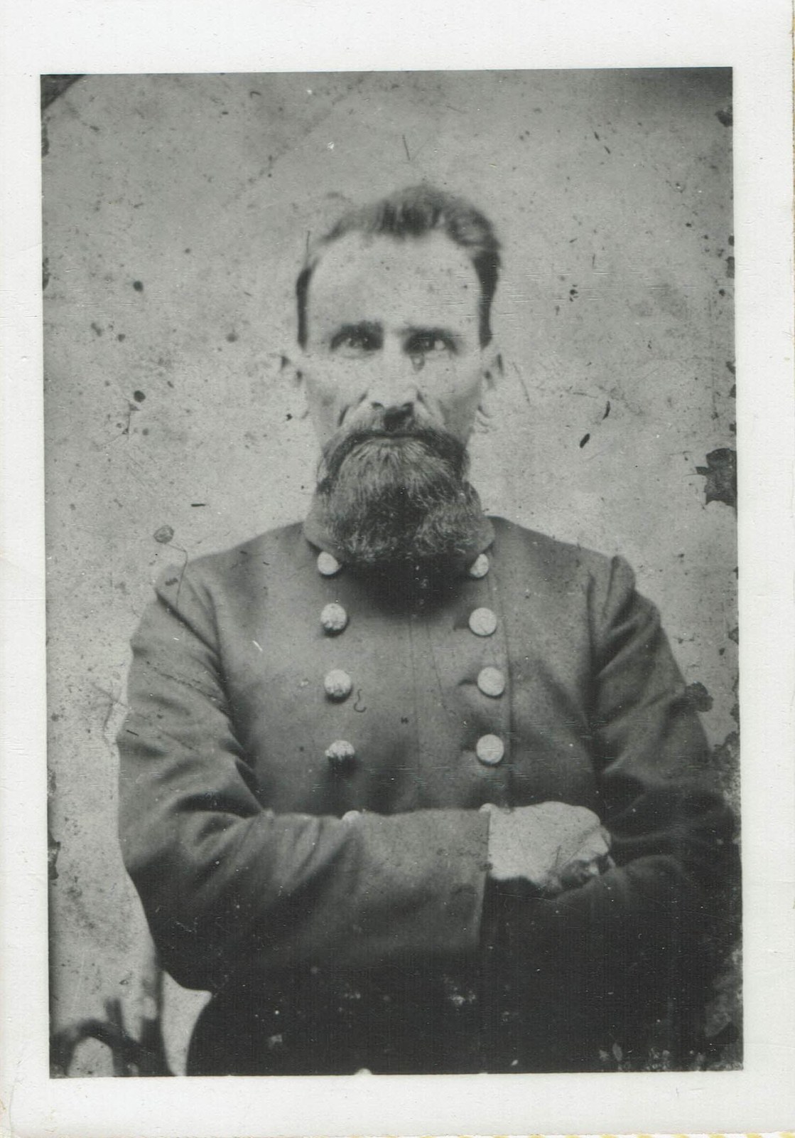 Seated portrait of John Sexton, a bearded man in a military-style coat